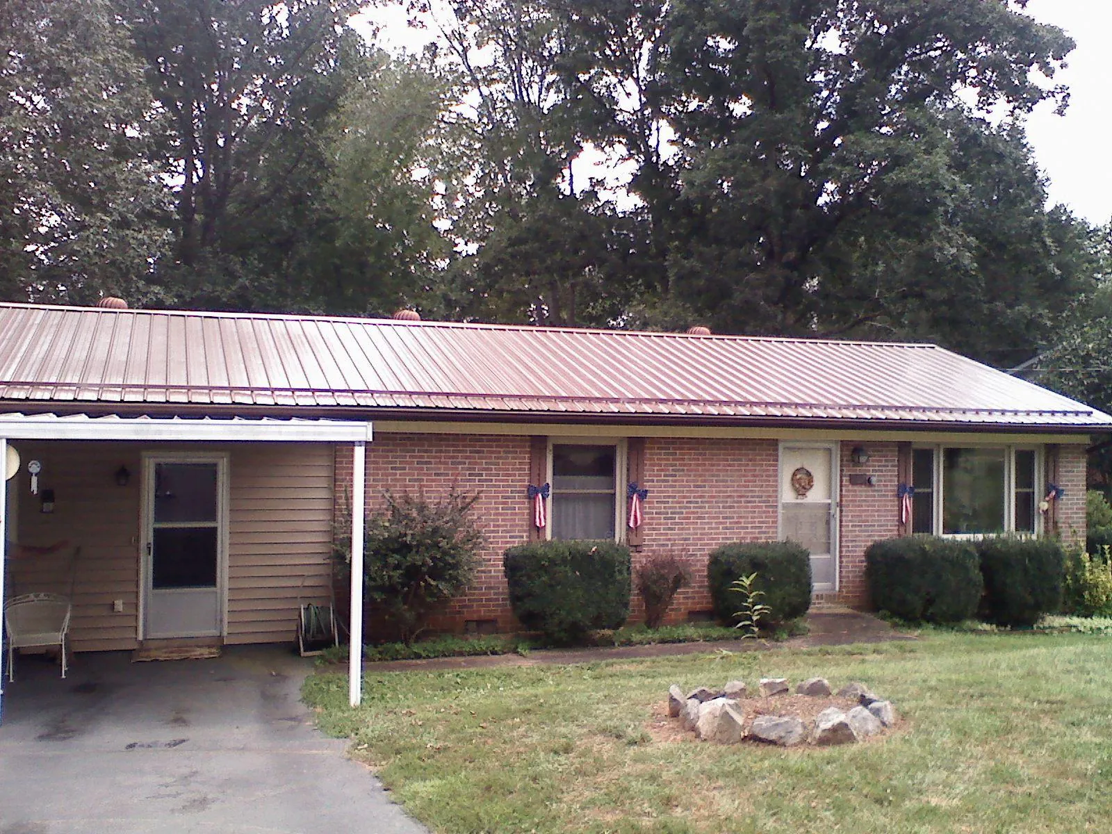Bronze metal roof and carport on a brick ranch home — Roof Repair work by our crew in Sandy